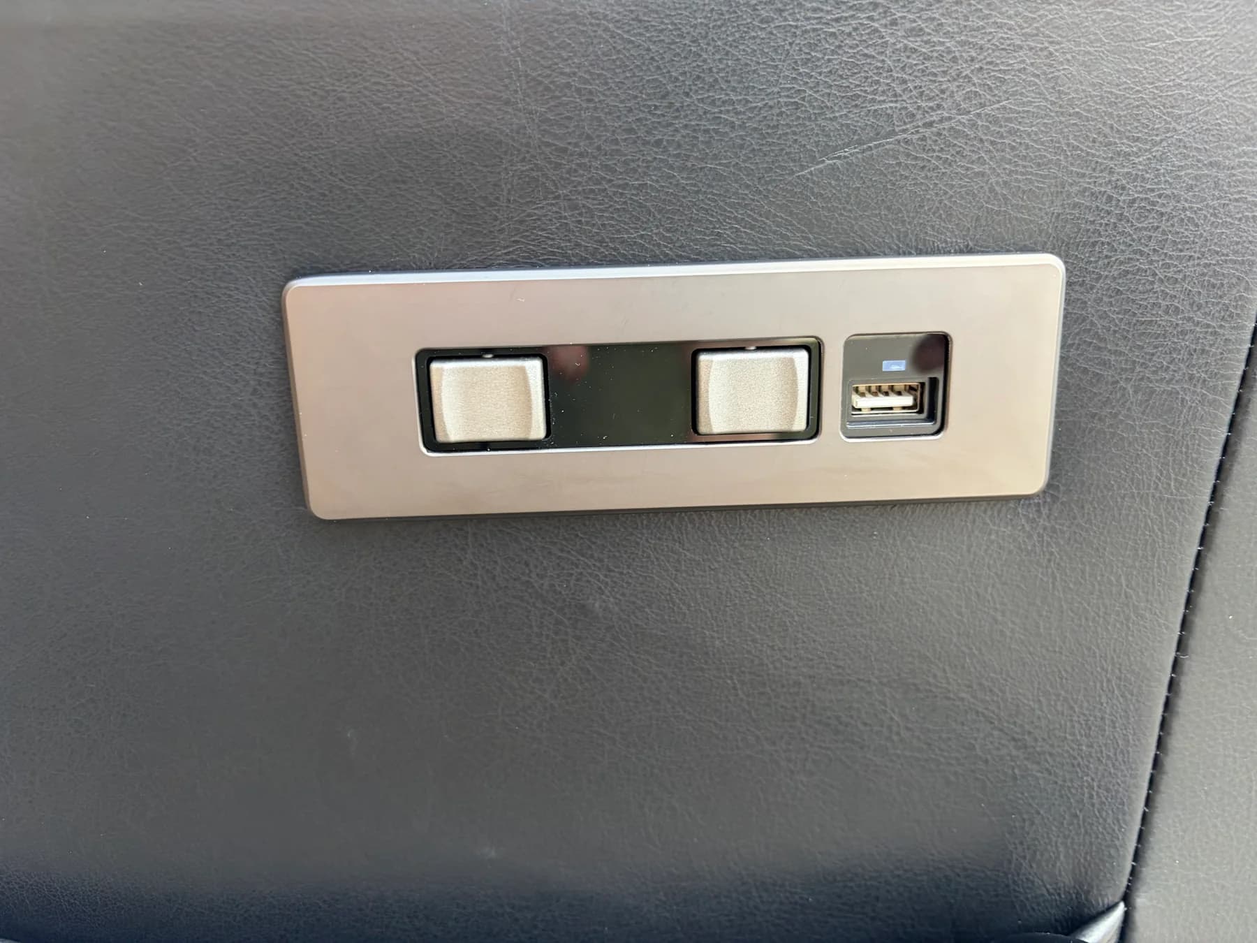 Built-in recliner switches and a USB connection on a leather chair
